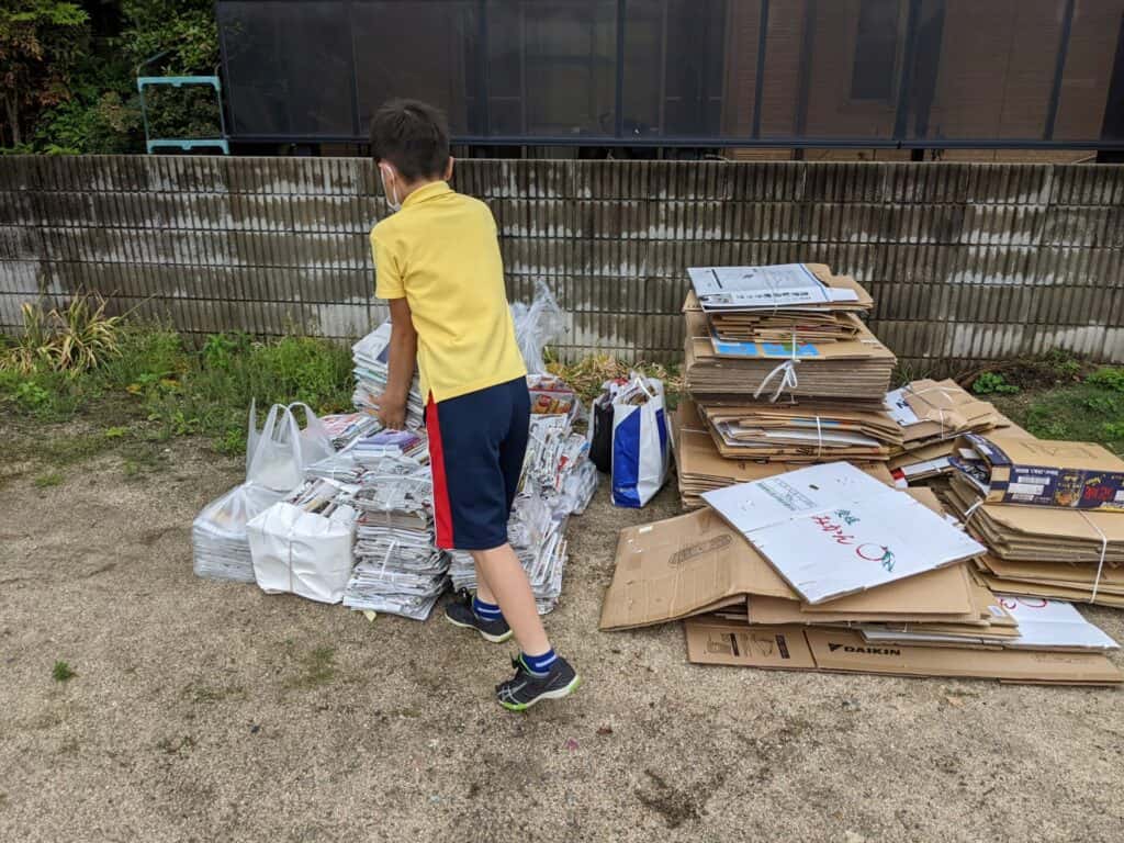 廃品回収途中の写真。資源ごみの集積所に子ども会の子どもがごみを集めている。