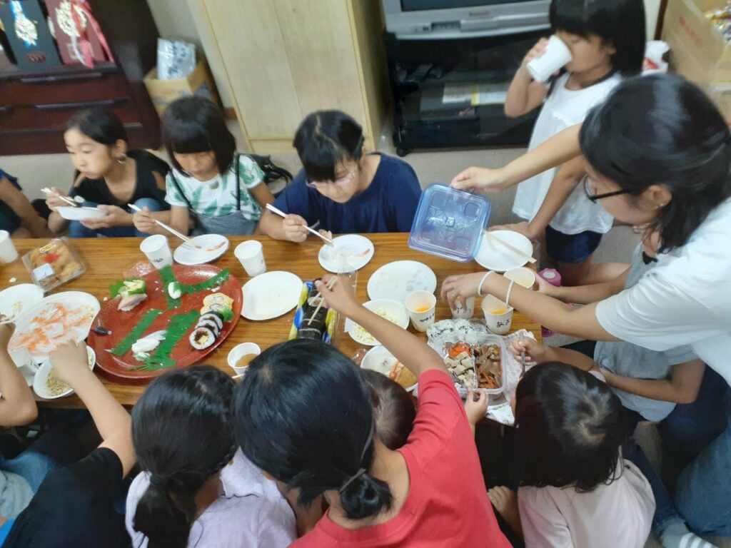 学区運動会後の打ち上げで子ども達がご飯を食べている写真